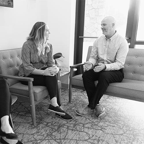 Doctor interviewing two dental candidates in the lobby of his practice.