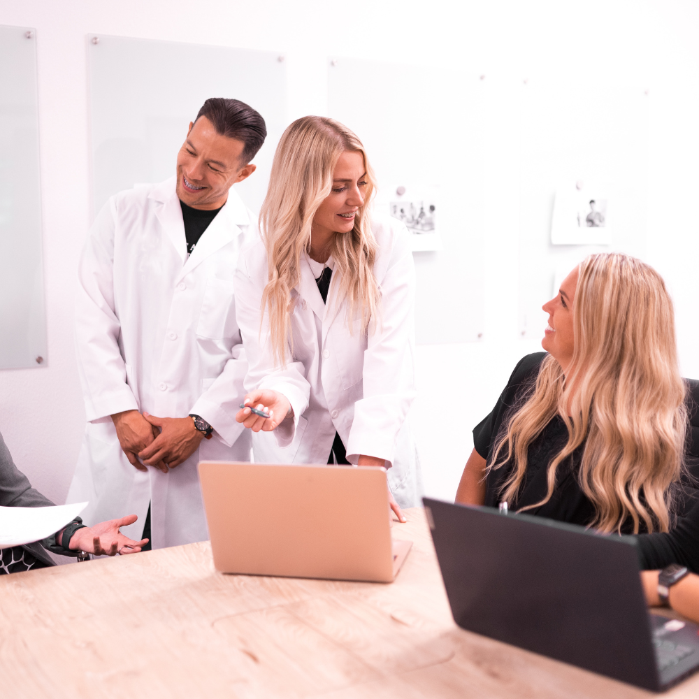 Two dentists, their team and consultants talking over computers